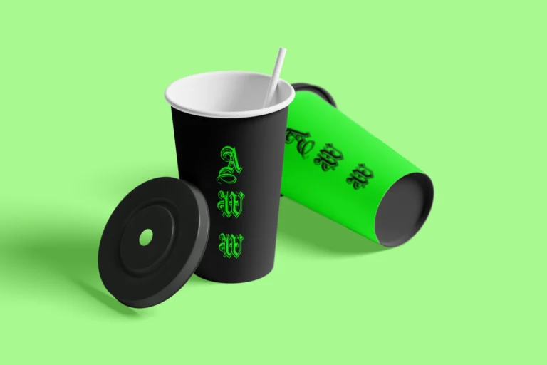 Black and green paper drink cups with a straw and separate black lid on a light green background